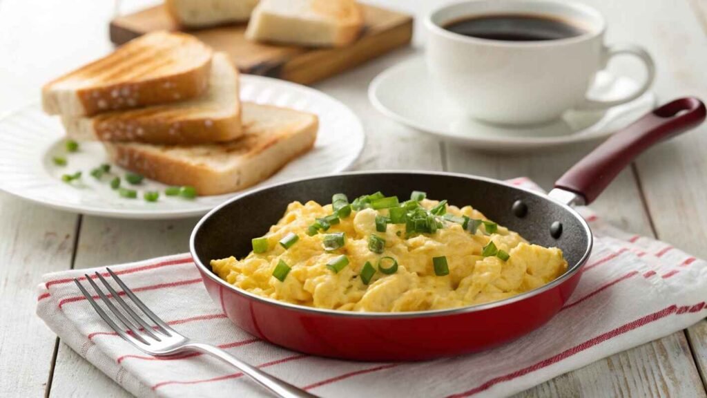 A Delicious Breakfast Scene Featuring Freshly Cooked Scrambled Eggs In A Re D Non Stick Frying Pan